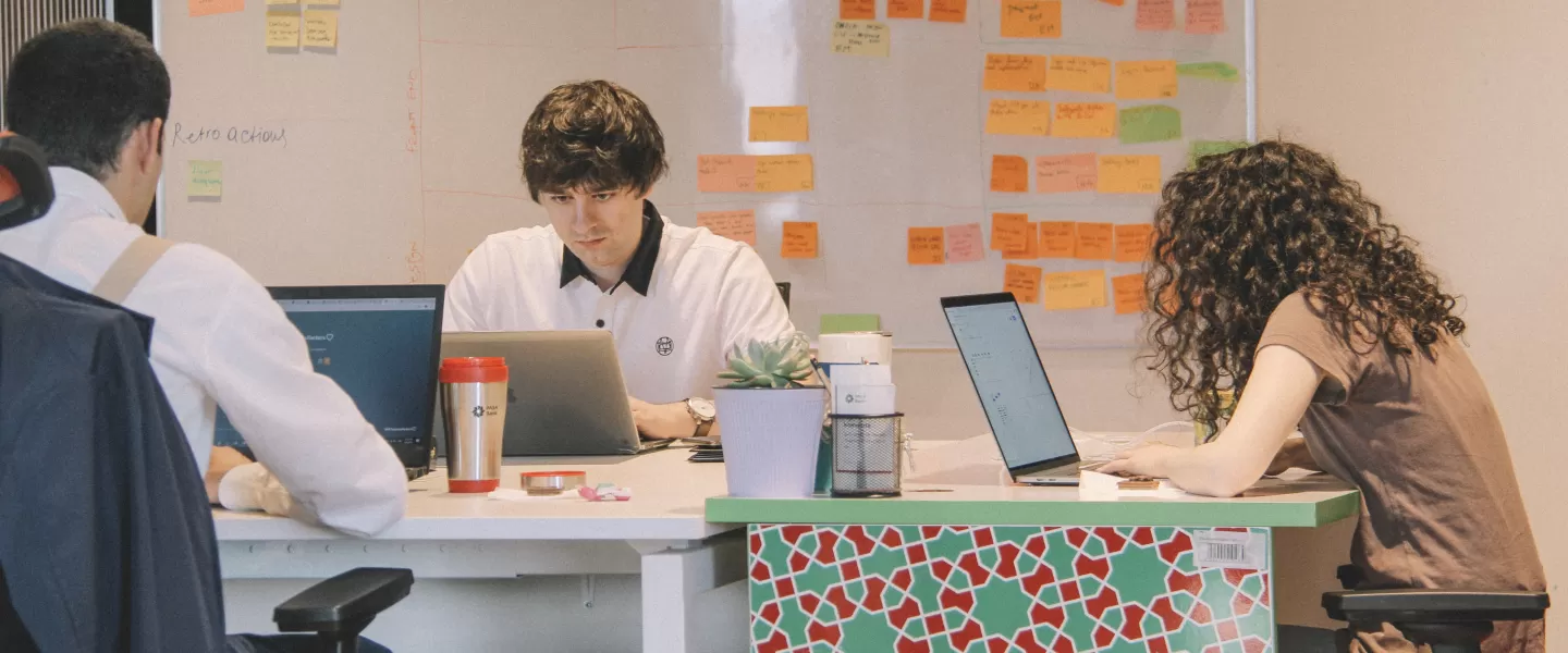 Trzy osoby pracujące przy biurku